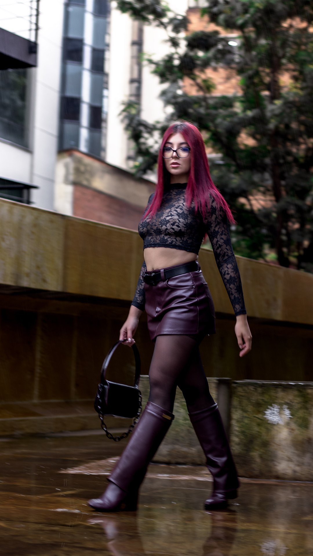 Caminando por una calle mojada, con top de encaje y botas de cuero